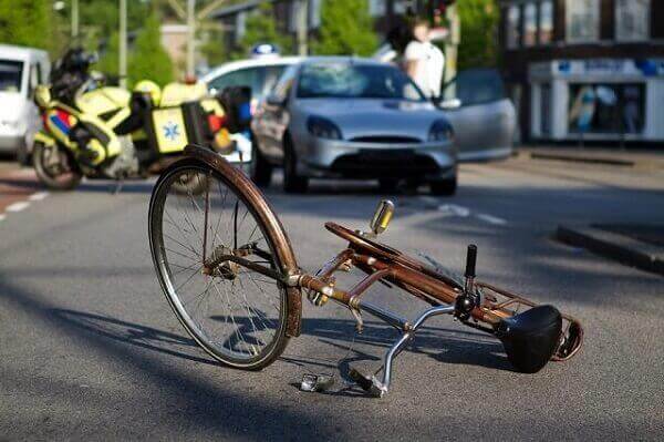 A wrecked bicycle left in the middle of the street after an accident.