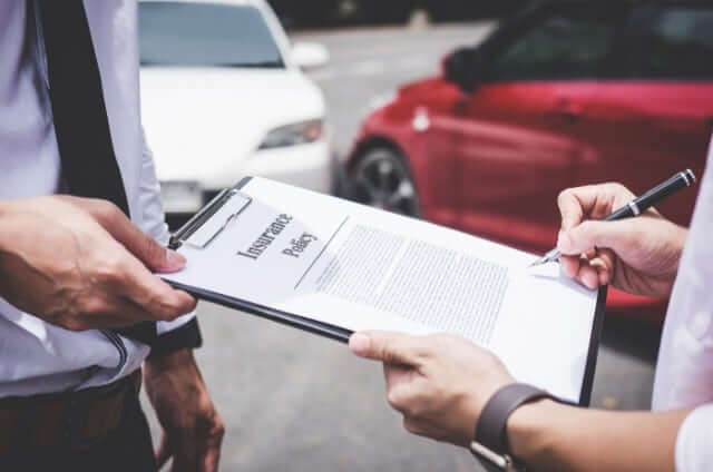 Signing an insurance policy in front of car accident
